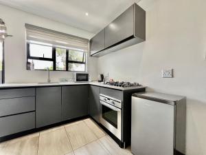 a kitchen with a stove and a refrigerator at No 6 On Cladon # Jadde Apartments in Chartwell