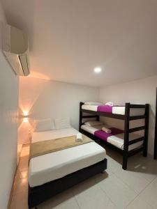a room with two beds in a room with a lamp at Hotel Plaza Roma in Ríohacha +28 photos