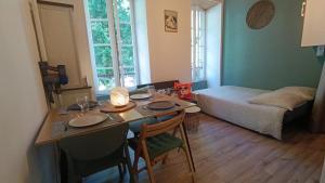 a living room with a table and a bed at Appartement 4 pers Montagne -draps et serviettes non fournis- in Eaux-Bonnes