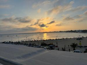 a crowd of people on a beach at sunset at honey moon zeinbe 4 in Hammamet
