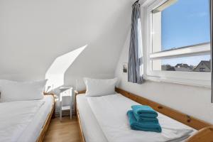 two beds in a small room with a window at Ferienwohnung Kleine Auszeit Nr 3 in Maasholm