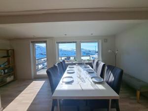 a dining room with a long table and blue chairs at Michelle's Yellow house in Ilulissat +5 photos