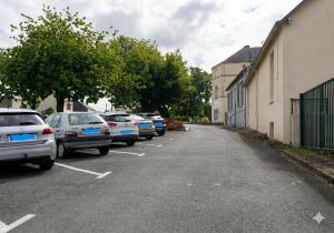 a row of cars parked in a parking lot at Au Bon Pasteur RDC proche des voies routières et du centre ville in Cholet