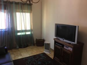 a living room with a flat screen tv on a stand at Lovely grandma house in Vila Viçosa +9 photos