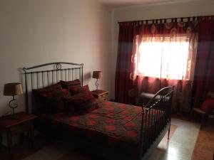 a bedroom with a bed and a window at Lovely grandma house in Vila Viçosa