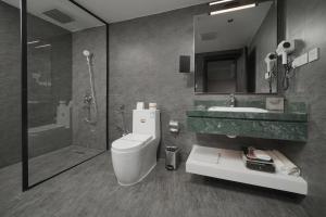 a bathroom with a toilet and a sink and a shower at Marvelous Hotel in Tabuk