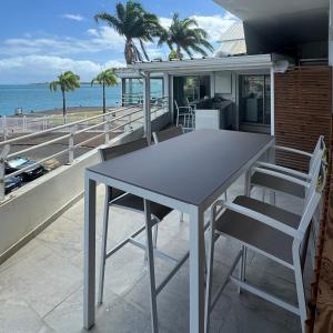 a table and chairs on a balcony with the ocean at Le Loft in Pointe-à-Pitre
