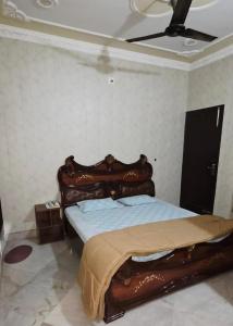 a bedroom with a bed with a wooden head board at StayStudio in Jammu