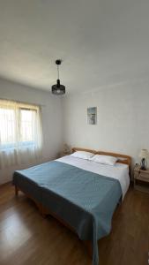 a bedroom with a large bed with a blue blanket at Laura Apartment in Tribunj