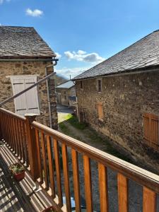 a balcony of a house with a wooden fence at La grange un refuge in Mijanès