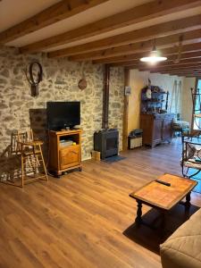 a living room with a couch and a tv at La grange un refuge in Mijanès