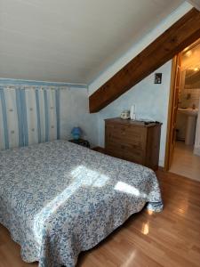 a bedroom with a bed and a wooden floor at La grange un refuge in Mijanès