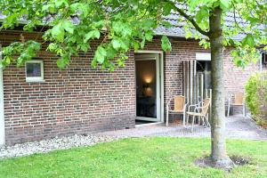 a brick house with a door and a table and chairs at Drouwenerzand Hotel in Drouwen