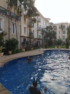 people swimming in a large pool in a building at Leela Homes - Backpacker's Nest in Arpora +11 photos