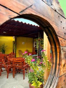 a patio with wooden chairs and tables and flowers at Hotel Plaza Roma in Ríohacha