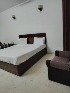 a bedroom with a bed and a couch in it at Hotel king palace family stay in Agra +10 photos
