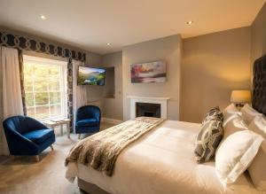 a bedroom with a large bed and a fireplace at Aberdunant Hall, Snowdonia in Porthmadog