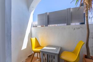 two yellow chairs and a table on a balcony at Casa de Océano in Tarifa