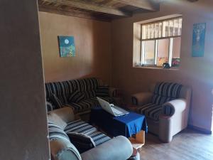 a living room with two couches and a laptop on a table at GAIA kuelap in Nuevo Tingo