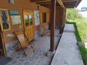 a porch of a house with a wooden door and chairs at GAIA kuelap in Nuevo Tingo