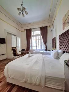 a large white bedroom with a large bed and a table at Dawn town palace in Cairo