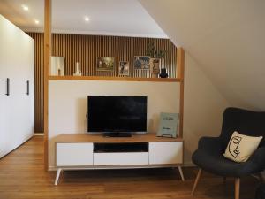 a living room with a television and two chairs at Ferienwohnung Siedlungsnest in Anklam