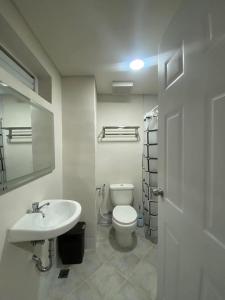 a white bathroom with a toilet and a sink at Iam Cozy Condo Mactan Airport in Lapu Lapu City +10 photos