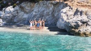 a group of people standing in the water on a beach at ARGO III Sailing Yacht in Skiathos