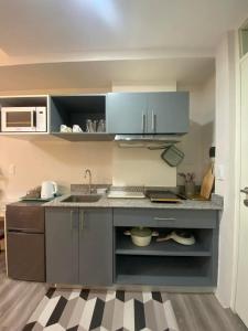 a kitchen with blue cabinets and a sink at Iam Cozy Condo Mactan Airport in Lapu Lapu City