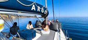 a group of people sitting on a boat in the water at ARGO III Sailing Yacht in Skiathos