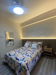 a bedroom with a bed with a blue comforter at Iam Cozy Condo Mactan Airport in Lapu Lapu City