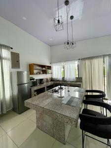 a kitchen with a large island in the middle at Arenal Views, Pool & 5min to Waterfall & Town in Fortuna