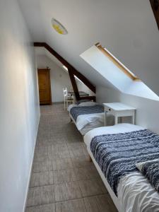 a row of beds in a room with stairs at La Grange de Flavigny in Flavigny
