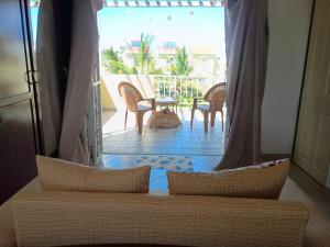 a living room with a couch and a view of a patio at Triplex - Suite parentale in Grande Gaube