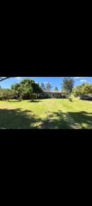 a large field of grass with trees and a building at Sitio de Lazer in Eldorado do Sul