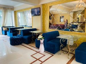 a living room with blue couches and a mirror at Villa Diamond in Chişinău