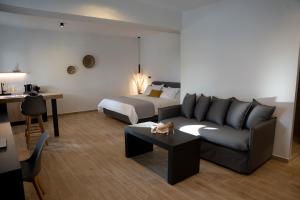 a living room with a couch and a bed at Τzegia Suites in Galissas