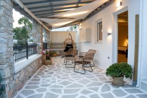 a patio with chairs and a table on a house at Τzegia Suites in Galissas