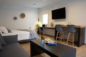a bedroom with a bed and a desk with chairs at Τzegia Suites in Galissas