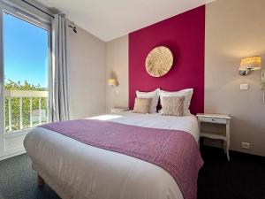 a bedroom with a large bed with a purple wall at Hôtel des Vignes - Juliénas in Juliénas +46 photos