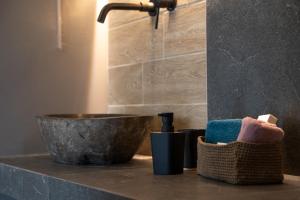 a bathroom counter with a sink and a bowl at Τzegia Suites in Galissas +45 photos