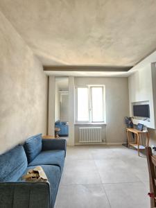 a living room with a blue couch and a television at Locazione turistica Corner 20 zona Clinica Piacenza in Piacenza