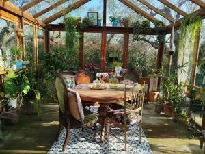 a wooden table in a conservatory with plants at Golden Camp in Falerna