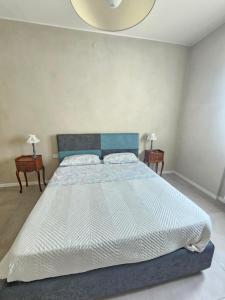 a large bed in a bedroom with two night stands at Locazione turistica Corner 20 zona Clinica Piacenza in Piacenza