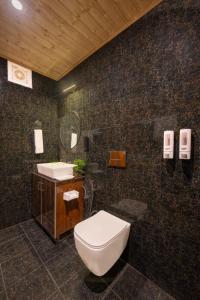 a bathroom with a toilet and a sink at The Charvi Regency l Multi Cuisine Restaurant l Conference Hall l Scenic Venues for Private Parties l Basic First Aid l Spacious Car Parking l Managed By ExoticStays Group in Shimla