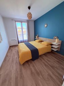 a bedroom with a large bed with blue walls and wooden floors at Le Terra Rosa - Proche Zoo & Lac de la ramée in Plaisance-du-Touch