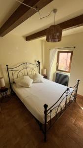 a bedroom with a bed with white sheets and a window at Ancient townhouse next castle in Vezzano Ligure