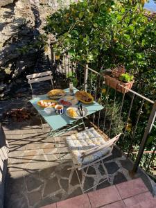 a table with plates of food on it next to a fence at Ancient townhouse next castle in Vezzano Ligure