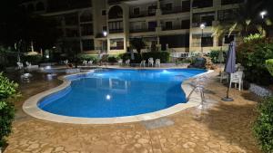 a large swimming pool in front of a building at Gladmar Apartment in La Mata
