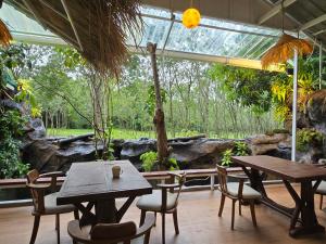 a patio with tables and chairs in front of a rock at Oasis2 Phuket Airport Glamping in Phuket
